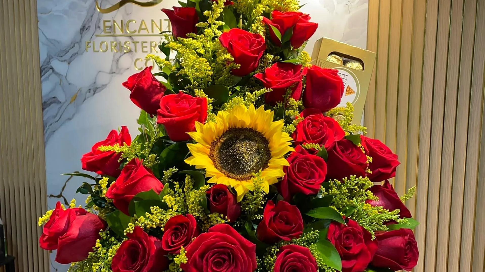 Arreglo de rosas rojas con girasol en la tienda